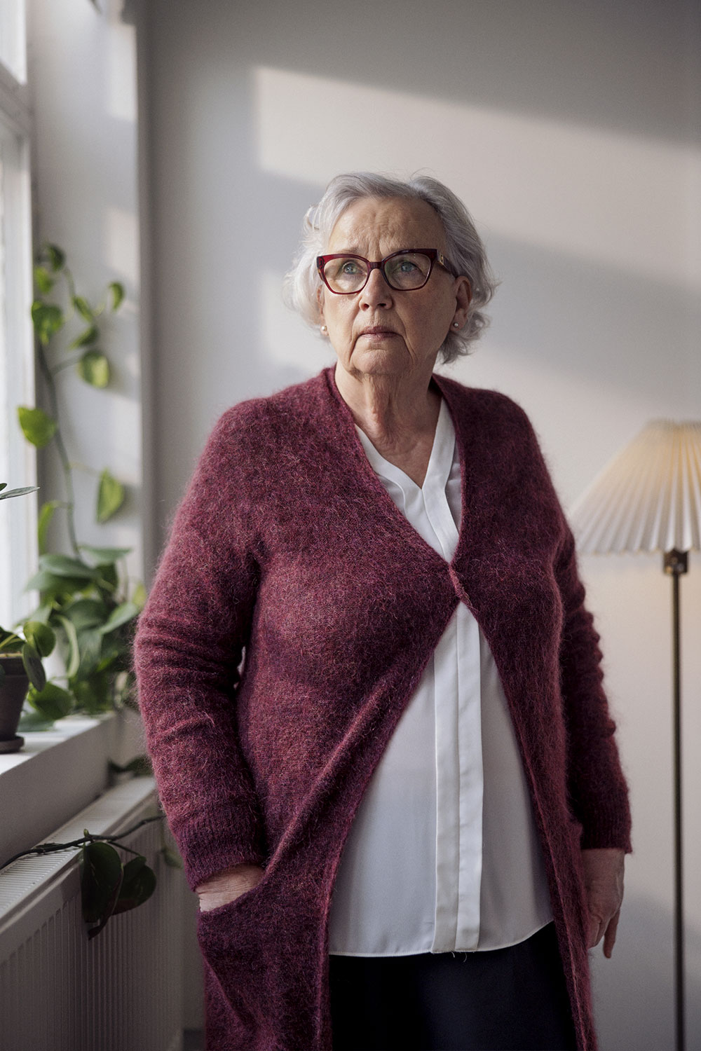 Vanhempi nainen katsoo ikkunasta